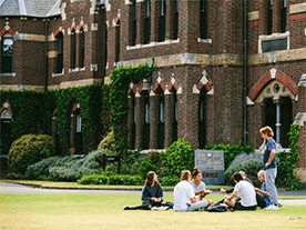 Students enjoying the picturesque ƵappCollege grounds in front of the most historic building